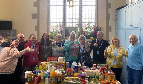 Food bank volunteers celebrate donations collected by Berkhamsted office employees.