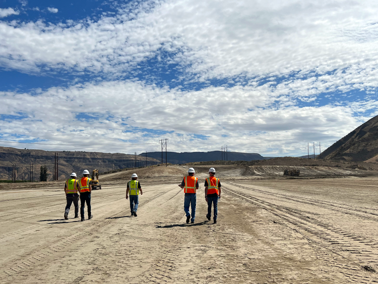 Five HDR employees walking near power transmission lines