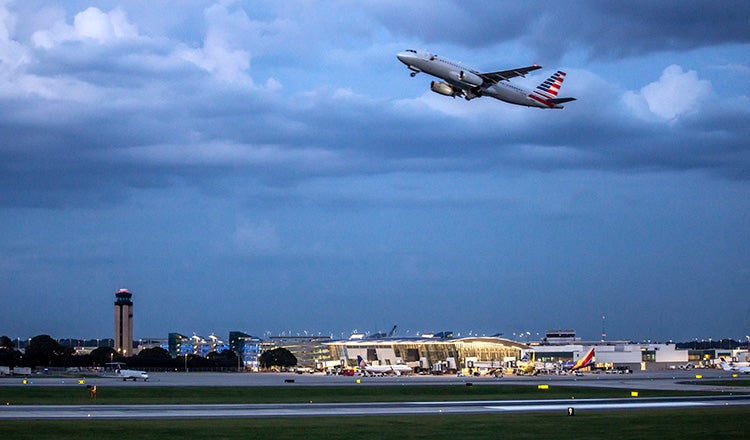 plane taking off with airport in background