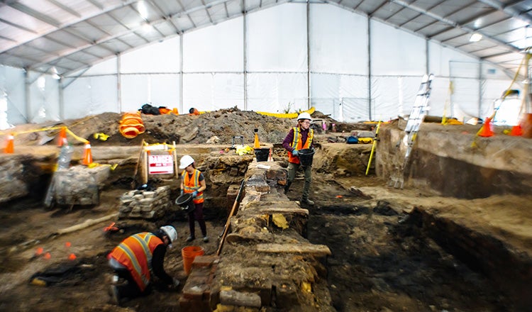 people digging through dirt during archeological investigation