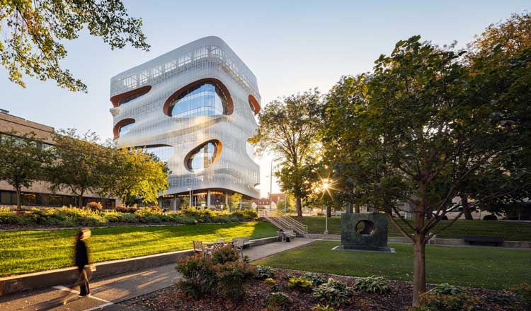 Exterior view of the Mayo Clinic Anna Maria and Stephen Kellen Building, with green grass in the foreground and soft daylight illuminating the facade.