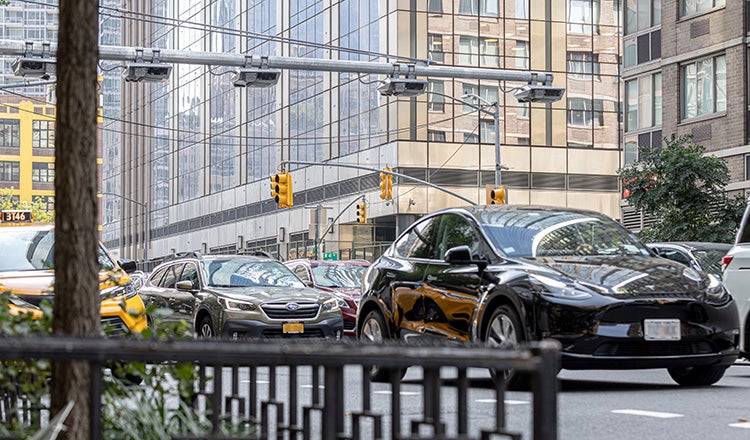 cars on nyc street underneath tolling cameras