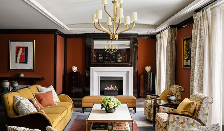 Interior of lounge area at The Beaumont Hotel, with soft furnishings and fire place in the background.