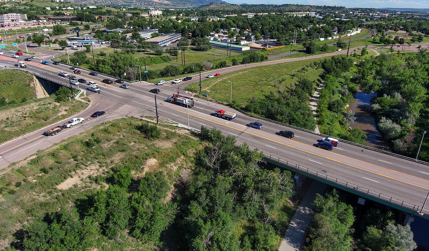 vehicles at intersection near a bridge